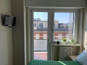 a room with a window with a view of a building at Bright Place Navigli in Milan