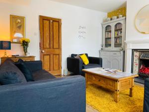 - un salon avec un canapé bleu et une table basse dans l'établissement Arden Holiday Lettings, à Stratford-upon-Avon