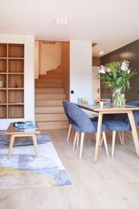 uma sala de jantar com uma mesa e cadeiras azuis em Magnifique Appartement Design Parking Chiberta em Anglet