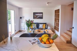 a living room with a table with a bowl of fruit at Magnifique Appartement Design Parking Chiberta in Anglet