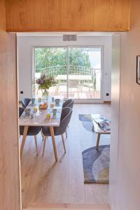 d'une salle à manger avec une table, des chaises et une fenêtre. dans l'établissement Magnifique Appartement Design Parking Chiberta, à Anglet