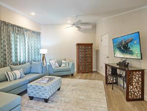 a living room with a blue couch and a table at Southwinds Beach House in Saint Peter