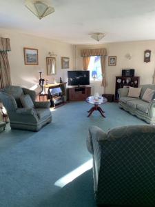 a living room with two couches and a tv at Bunillidh in Drumnadrochit