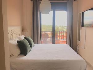 sypialnia z łóżkiem i balkonem z widokiem na okolicę w obiekcie Duplex Penthouse in Estepona- Mountain and Sea views w mieście Estepona