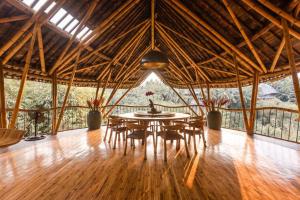 una sala da pranzo con tavolo e sedie in un edificio di Sharma Springs 5 bds Luxurious Bamboo Mansion Pool a Bringkit