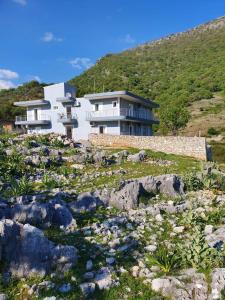 a house on top of a hill with rocks at Victoria Studio Himara in Himare