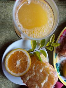 einen Teller mit einer Tasse Kaffee und einem Stück Orange in der Unterkunft Pousada Recanto da Montanha in Visconde De Maua