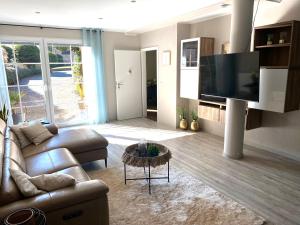 a living room with a couch and a flat screen tv at Ferienwohnung Feiden Eifel-Mosel Lounge in Greimersburg