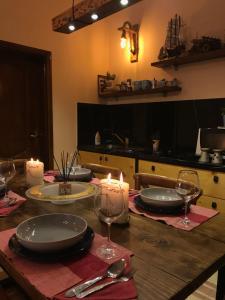 einen Holztisch mit Tellern, Gläsern und Kerzen darauf in der Unterkunft Cozy big apartment with balcony in Tirana