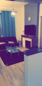 a living room with a couch and a tv at Appartement 48m2 pour 6 personnes au centre ville historique avec parking gratuit et une borne de recharge pour voiture à 10 metres in Avallon