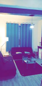 a living room with a red couch and blue curtains at Appartement 48m2 pour 6 personnes au centre ville historique avec parking gratuit et une borne de recharge pour voiture à 10 metres in Avallon