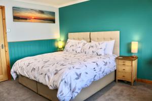 a bedroom with a bed with a blue wall at An-Airidh Bed & Breakfast Portree in Portree