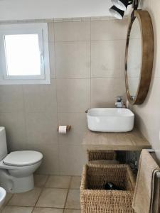 a bathroom with a sink and a toilet and a mirror at Chalet La Rosa in Cala Blanca