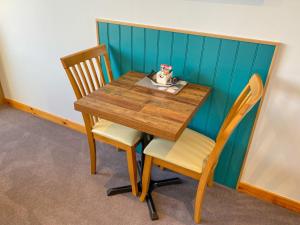 a wooden table with two chairs and a table and chairsuggest at An-Airidh Bed & Breakfast Portree in Portree