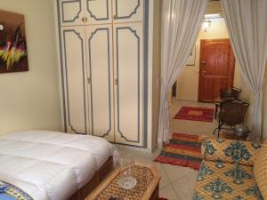 a room with a bed and a chair and a door at Appartement Wassim - Gueliz in Marrakech