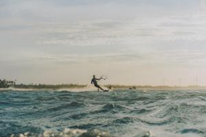 a man riding a wave on a surfboard in the ocean at KANAHA BEACH VILLA in Icaraí