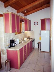 una cucina con armadietti viola e frigorifero bianco di Villa Belvedere - Best panoramic sea view apts a Vasilikós