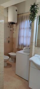 uma casa de banho com um lavatório, um WC e um espelho. em Al Civico 365 em Castelluzzo