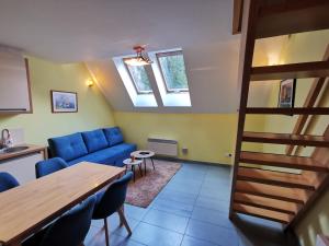 a living room with a blue couch and a table at Wellness Apartmány Fatrapark 1 Malinô Brdo in Ružomberok