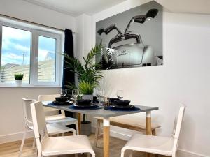a dining room with a table with a toaster on the wall at NEW Beautiful Large 3 bedroom House - 5 Minutes to the nearest Beach! - Great Location - Garden - Parking - Fast WiFi - Smart TV - Newly decorated - sleeps up to 7! Close to Poole & Bournemouth & Sandbanks in Lytchett Minster