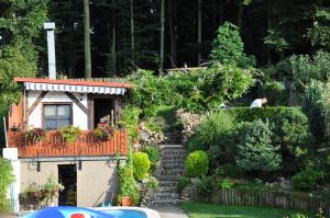 a house with a staircase in a garden at Apartmán Bílá Hora - Roudná in Pilsen