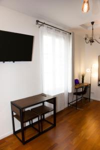 a living room with a table and a tv on a wall at Les Lofts De Provins Apt 2 in Provins