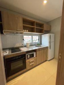 a kitchen with wooden cabinets and a white refrigerator at Edificio El Arbol piso 2 in Corrientes