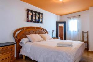 1 dormitorio con 1 cama grande y cabecero de madera en Casa de Pueblo, en Martos