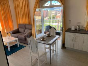 cocina y sala de estar con mesa y sofá en Apartamentos Sanjuan, en Porriño