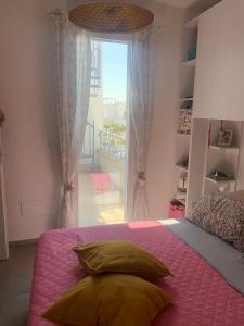 1 dormitorio con 1 cama con manta rosa y ventana en Villa Medea, en Torre Lapillo