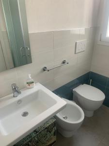 uma casa de banho com um lavatório branco e um WC. em Villa Medea em Torre Lapillo