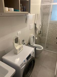 uma máquina de lavar roupa na casa de banho com WC em Villa Medea em Torre Lapillo