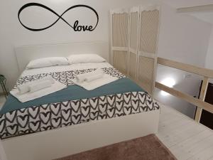 a bedroom with a bed with a love sign on the wall at mungiBEDdu Apartment in Catania