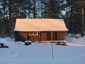 una cabina con tetto innevato nella neve di Båtstø Camping a Elga