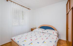 biała sypialnia z łóżkiem z niebieskim zagłówkiem w obiekcie 1 Bedroom Nice Apartment In Stara Baska w mieście Stara Baška