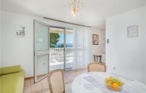 a dining room with a table and chairs and a balcony at 1 Bedroom Nice Apartment In Stara Baska in Stara Baška