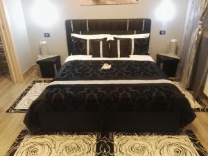 a bedroom with a large black bed with a rug at Lilium in LʼAquila