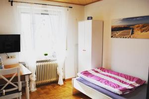 Schlafzimmer mit einem Bett, einem Schreibtisch und einem Fenster in der Unterkunft Zimmervermietung Familie Kolb in Oberessendorf