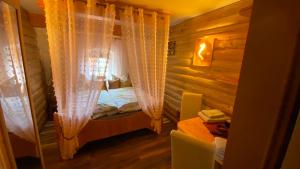 Schlafzimmer mit einem Bett mit Vorhängen und einem Tisch in der Unterkunft Froeschlein 2 - no Gitters & craftsman in Ilmenau