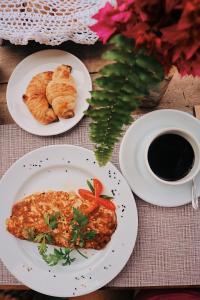 una mesa con dos platos de comida y una taza de café en Junduh Brasil Pousada e Restaurante, en Icaraí