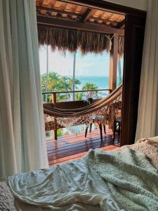 a bedroom with a hammock and a view of the ocean at Junduh Brasil Pousada e Restaurante in Icaraí