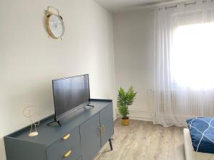 ein Wohnzimmer mit einem TV auf einer Kommode in der Unterkunft Blaue Insel neben Hbf-Duisburg in Duisburg