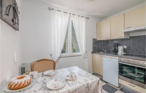 a kitchen with a table with a plate of food on it at Stunning Apartment In Stara Baska With Wifi in Stara Baška