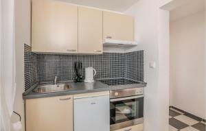 a kitchen with white cabinets and a sink at Stunning Apartment In Stara Baska With Wifi in Stara Baška