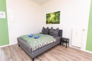 a bedroom with a bed with blue pillows on it at FULL HOUSE Studios - Rosenhof Apartments in Chemnitz