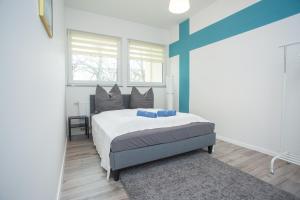 a bedroom with a bed with a blue accent wall at FULL HOUSE Studios - Rosenhof Apartments in Chemnitz