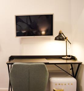a desk with a monitor and a lamp and a chair at HOMELY STAY Studio 2 in Munich