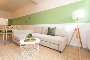 - un salon avec un canapé et une table dans l'établissement FULL HOUSE Studios - Rosenhof Apartments, à Chemnitz