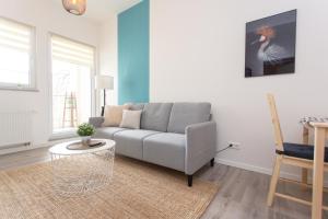 a living room with a couch and a table at FULL HOUSE Studios - Rosenhof Apartments in Chemnitz
