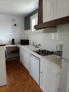 a kitchen with white cabinets and a stove top oven at gite le sarlat d'oie in Sarlat-la-Canéda